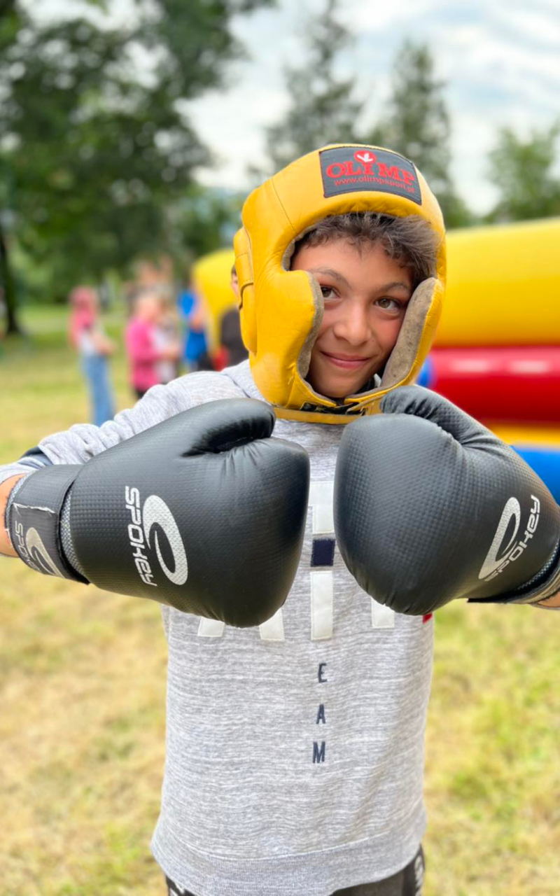 chłopiec w rękawicach bokserskich i żółtym kasku ochronnym